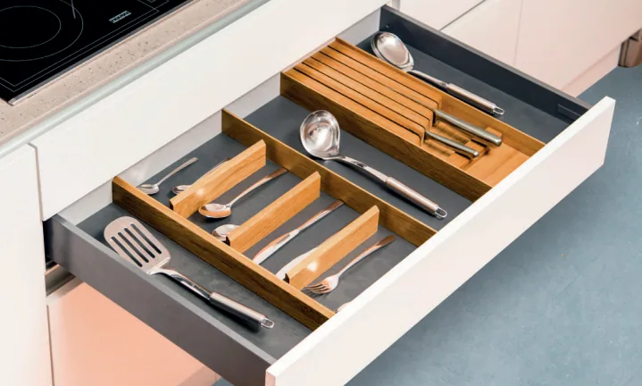 Accessoires bicolores en bois installés dans un tiroir de cuisine