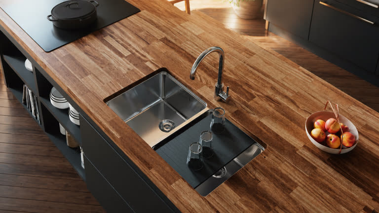 Évier inox avec égouttoir installé dans un plan de travail en bois