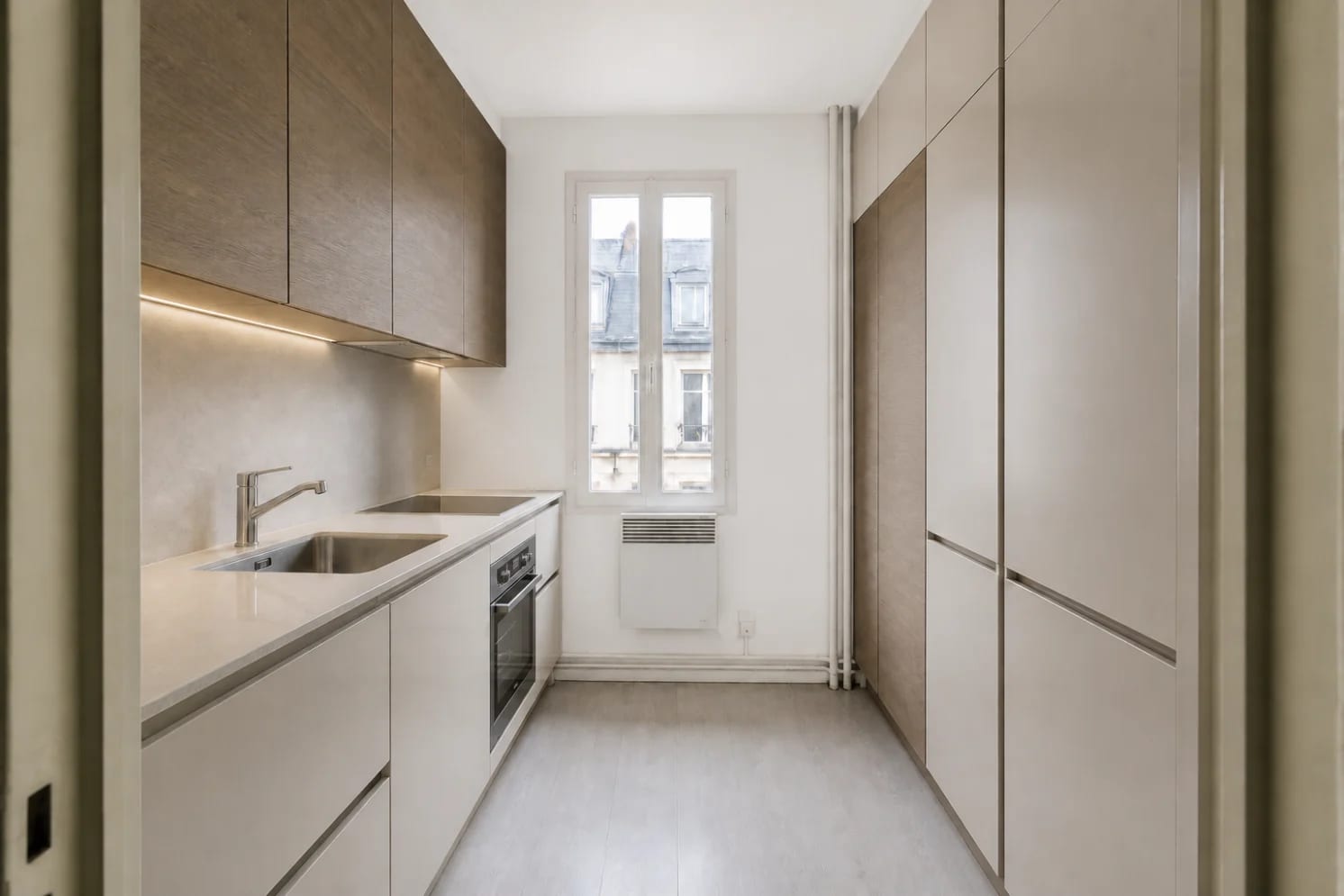 Même petite cuisine rénovée avec panneau mural, rangements toute hauteur et four sous le plan de travail
